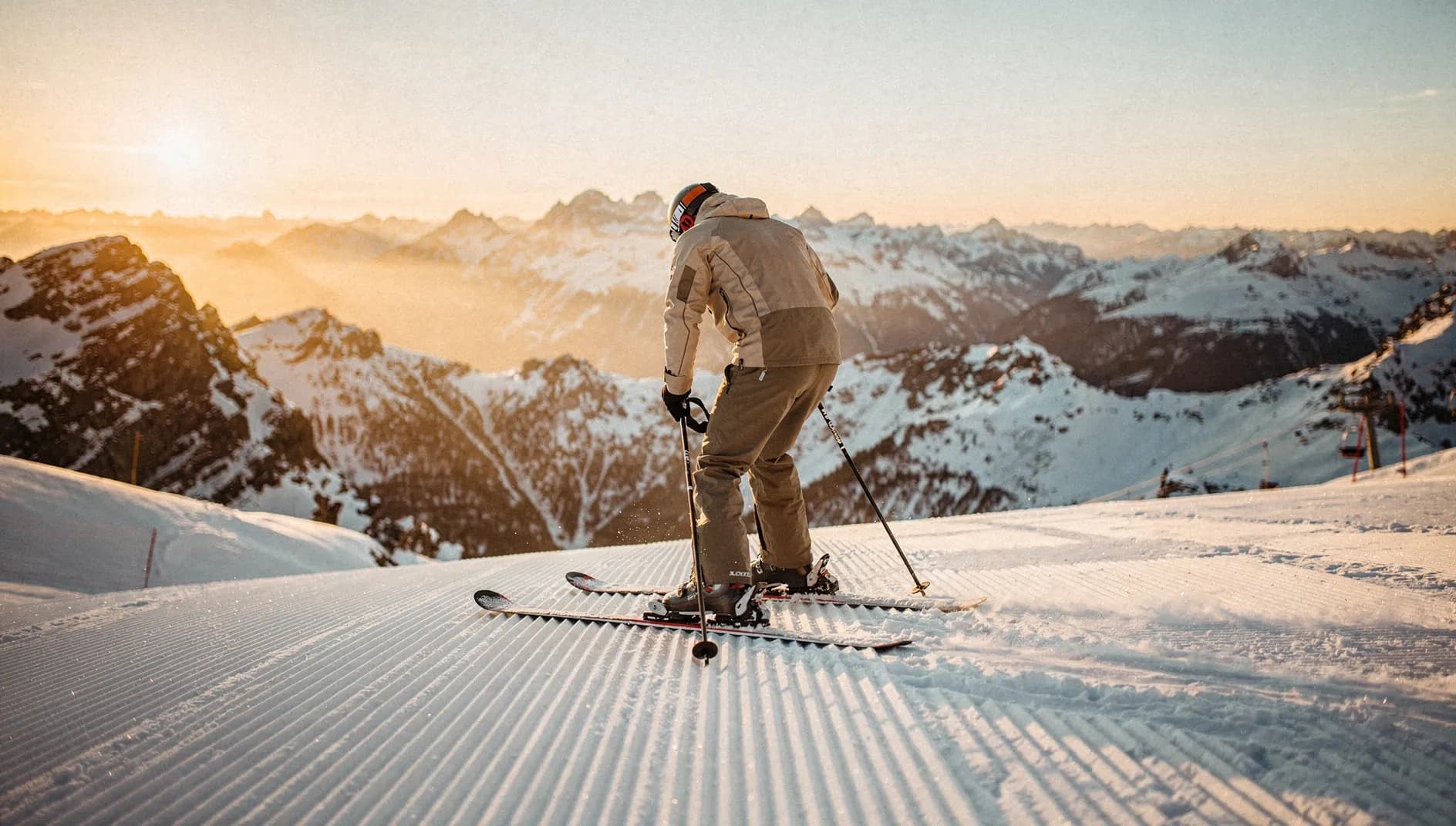 Skifahrer steigt oben am Hang in die Bindung